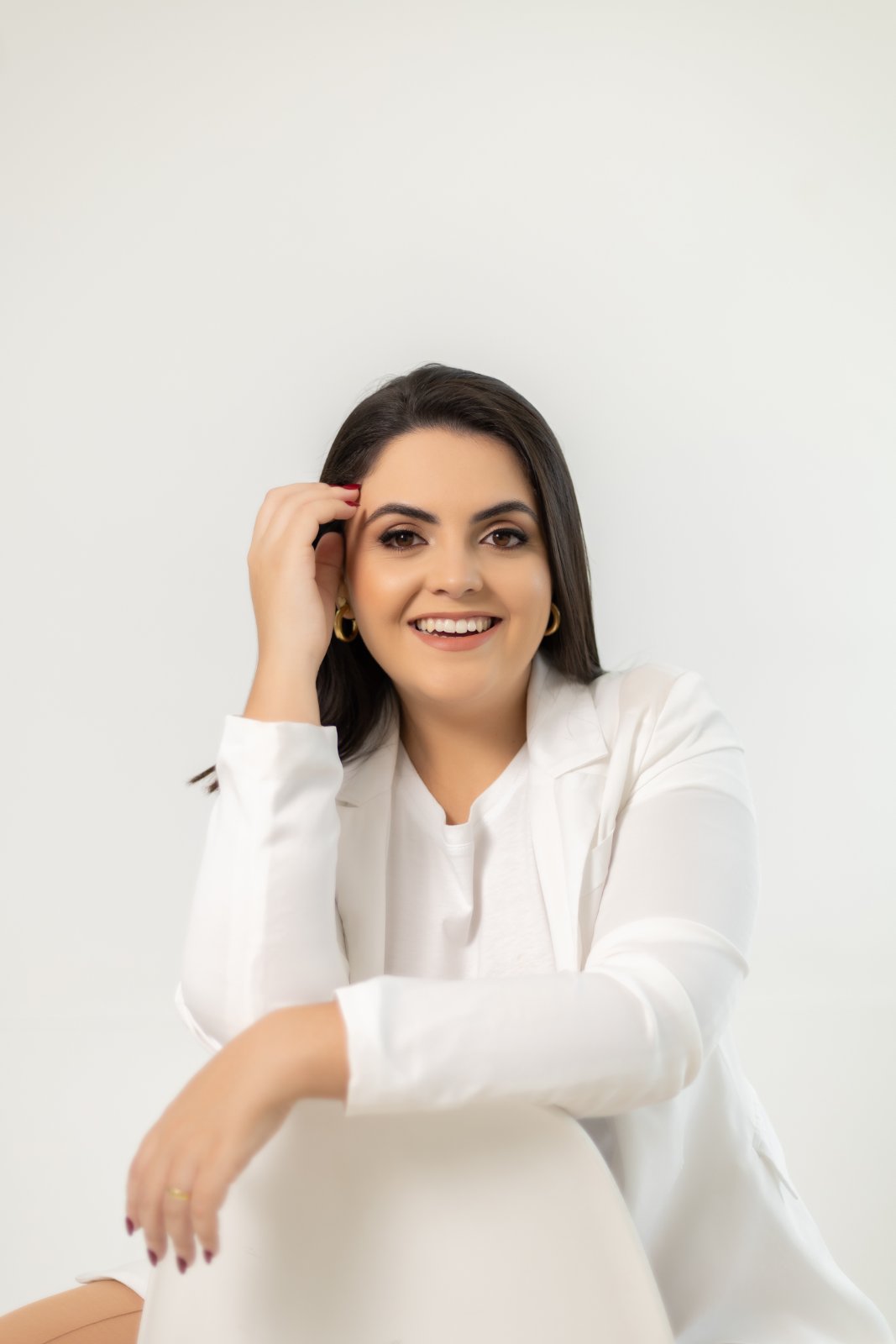 Luana Caroline Silva Vieira, psicóloga, sorrindo de blazer branco